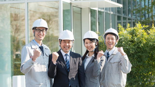 ガッツポーズをする4人の建設業者