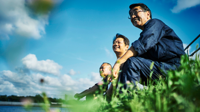 河川敷の建設現場で休憩する笑顔の建設業者